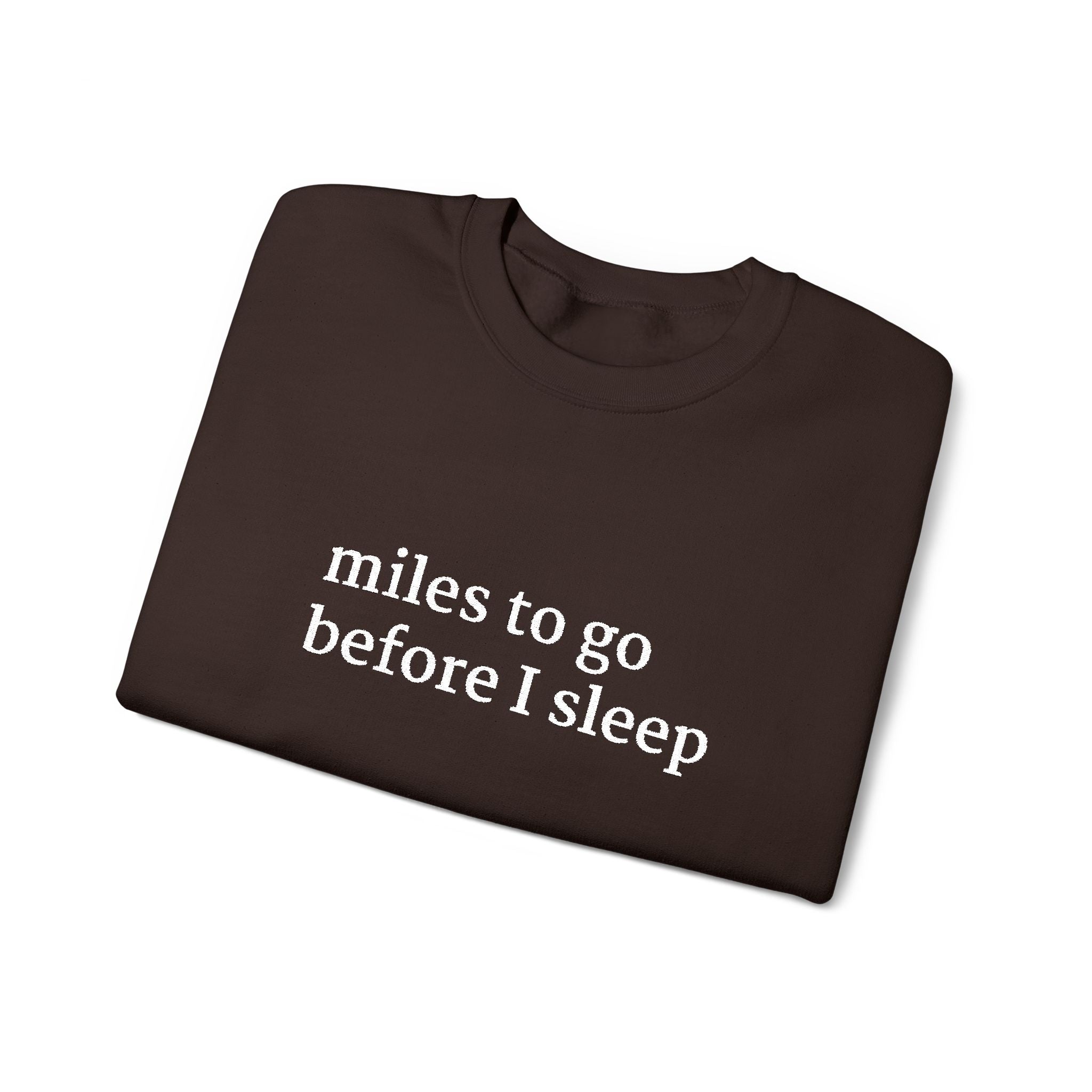Folded chocolate brown sweatshirt with 'miles to go before I sleep' text on a white background