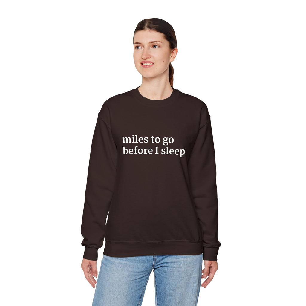 Model wearing a chocolate brown sweatshirt with 'miles to go before I sleep' text on a white background