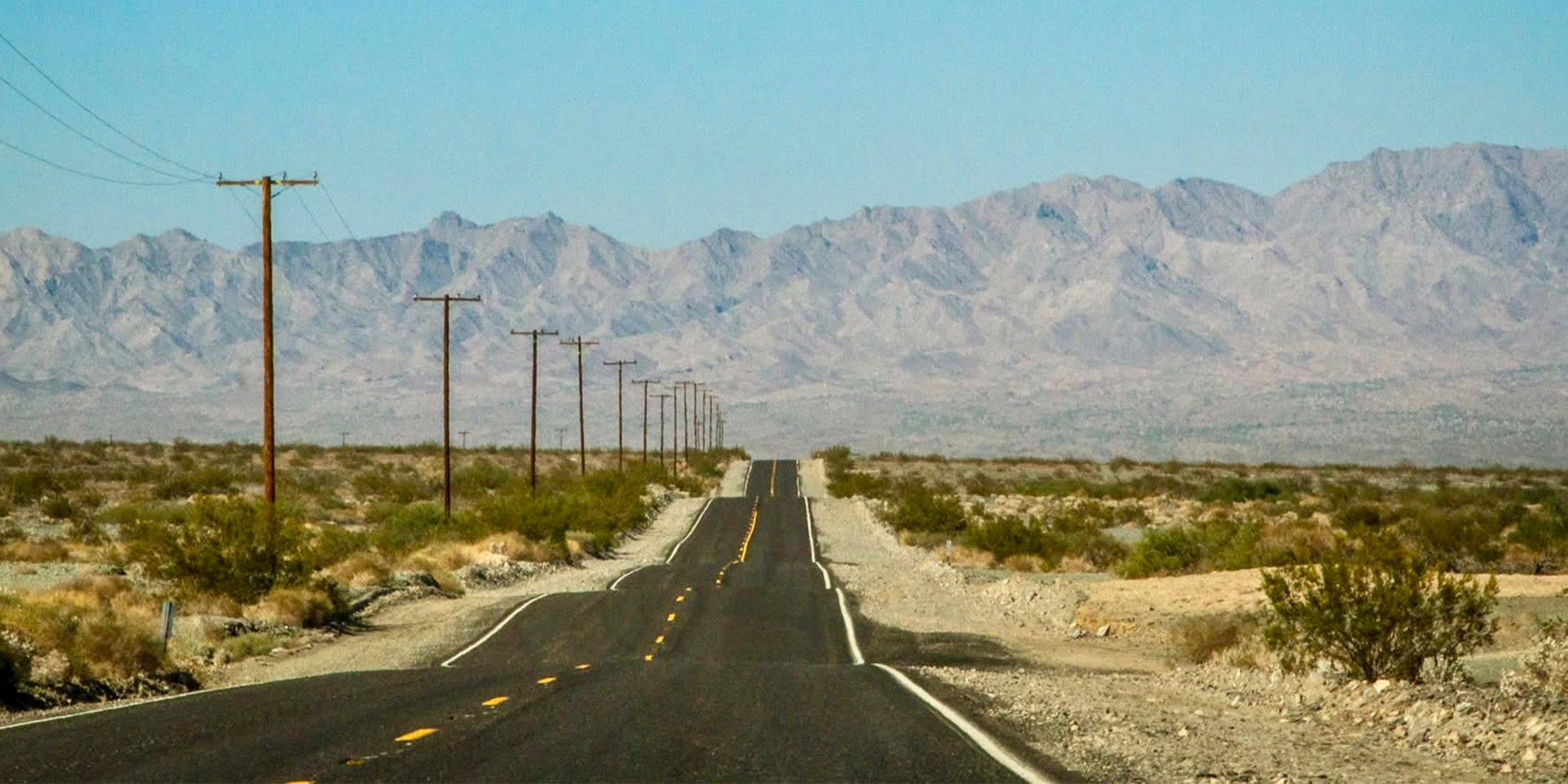 Scenic outdoor lifestyle hero image with Wanderfolk Collective brand tagline "Life Lived Wide Open." "Crafted good with a road worn heartbeat for wanders, homebodies, and storytellers." 