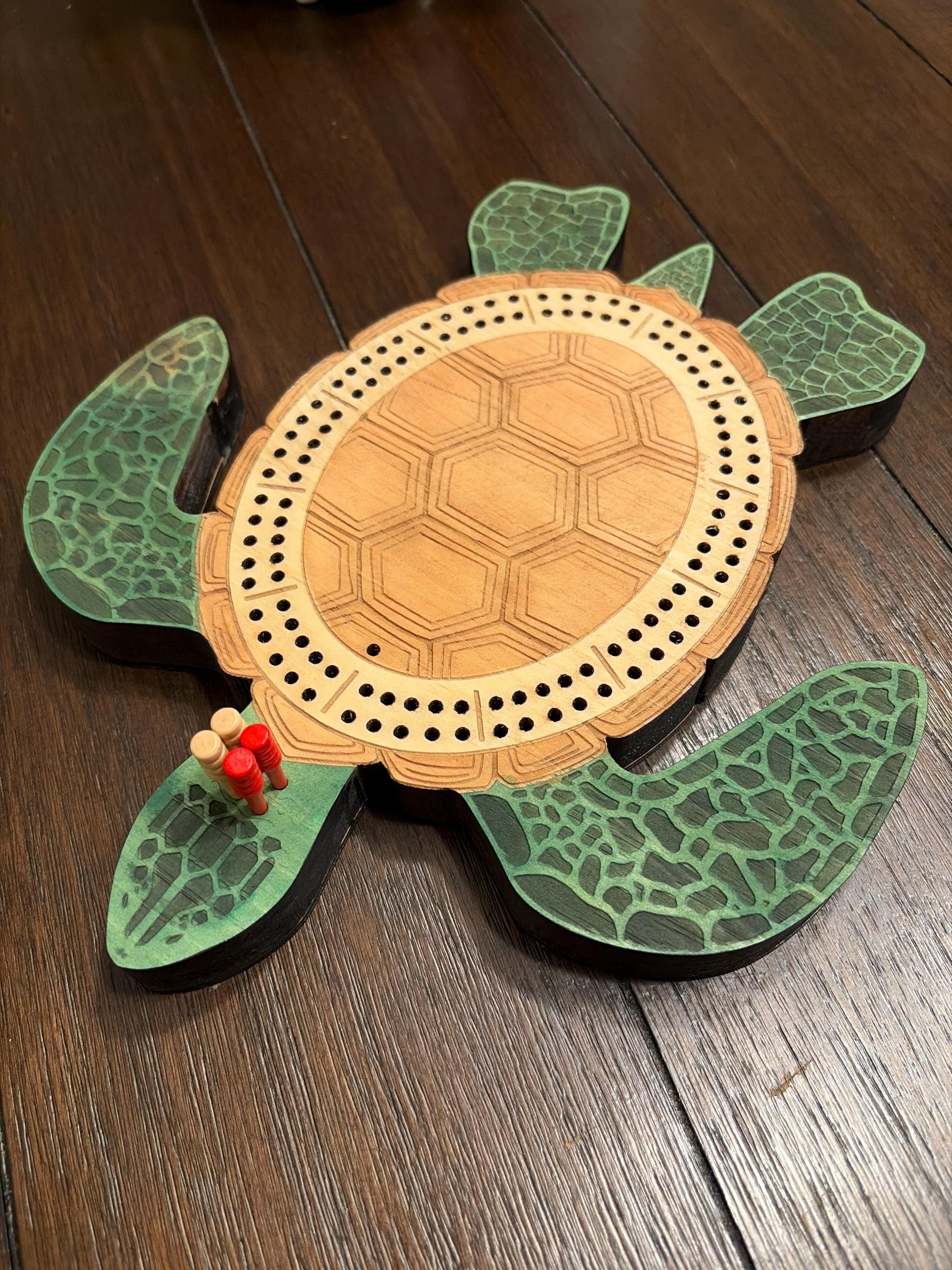 Wooden turtle-shaped cribbage board on a wooden surface